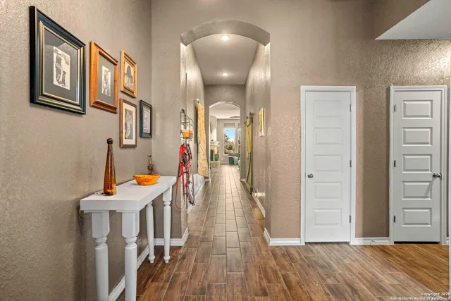 a view of a hallway with wooden floor and staircase