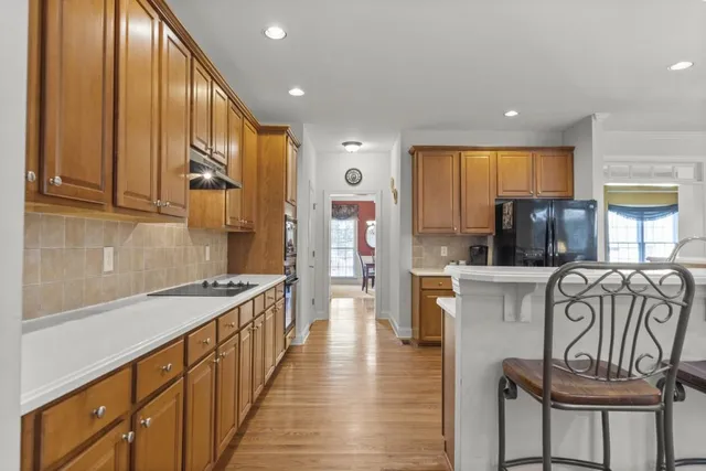 a kitchen with kitchen island granite countertop wooden cabinets a counter top space and stainless steel appliances