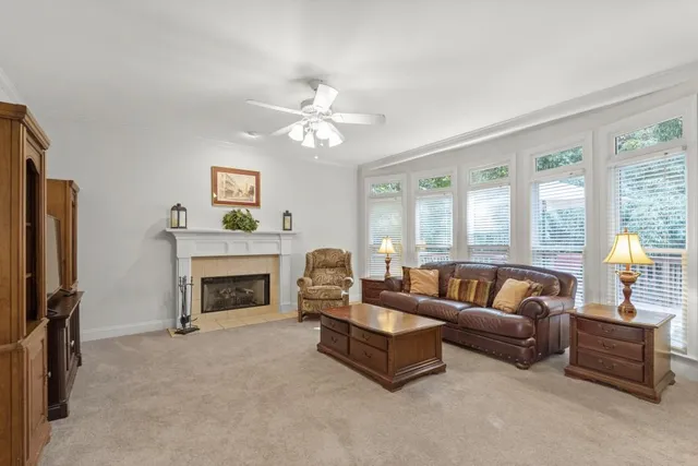 a living room with furniture a fireplace and a large window
