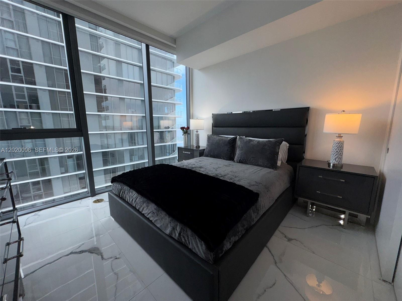 788 Northeast 23rd Street, Unit 1202 Miami, FL 33137 - Photo 28 of 64 a bedroom with a bed and a night stand