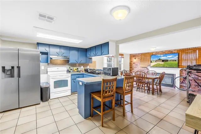 a dinning area with stainless steel appliances kitchen island granite countertop a table and chairs