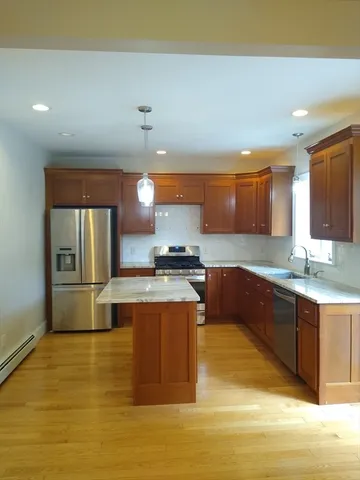 a large kitchen with stainless steel appliances granite countertop a sink and a stove