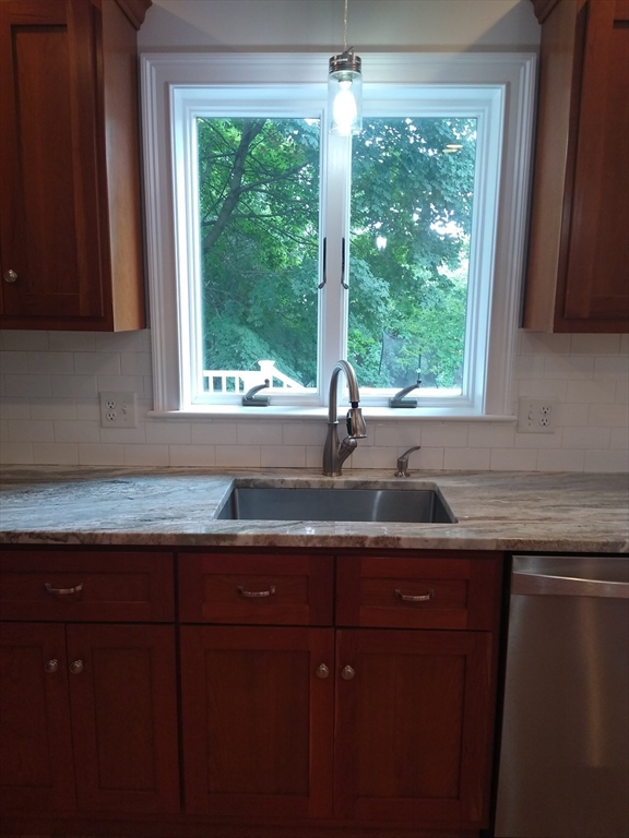 134 Jackson Street Cambridge, MA 02140 - Photo 3 of 22 a kitchen with granite countertop sink window and cabinets