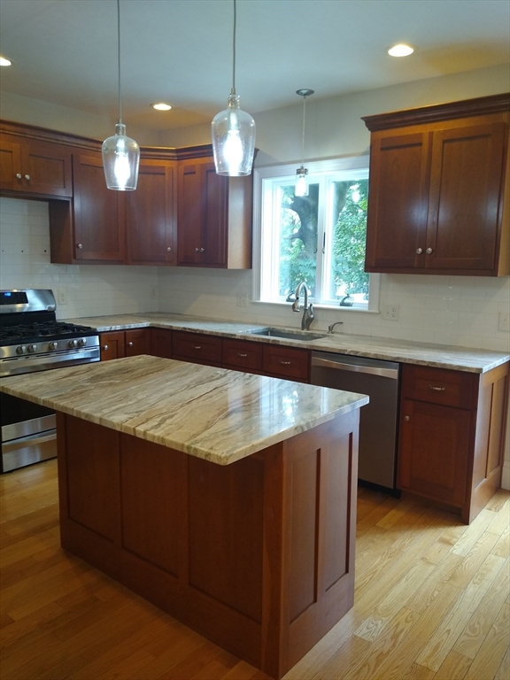 134 Jackson Street Cambridge, MA 02140 - Photo 4 of 22 a kitchen with kitchen island granite countertop a sink a counter space appliances and cabinets