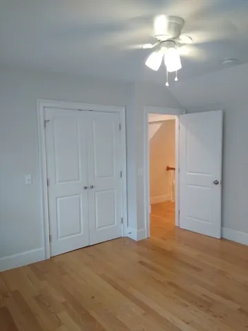 a view of an empty room with a chandelier fan
