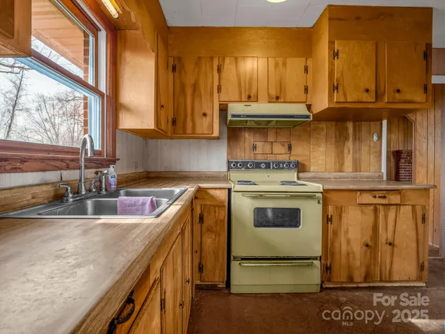 a bathroom with a granite countertop sink and a window