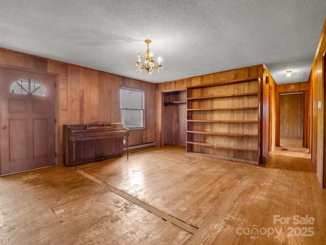 a view of an empty room with a fireplace and a window