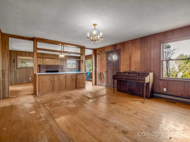 a view of a livingroom with furniture a chandelier and wooden floor