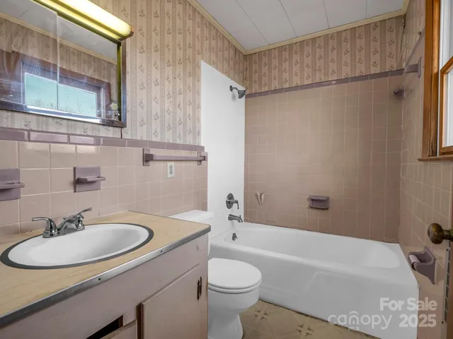 an empty room with windows and ceiling fan