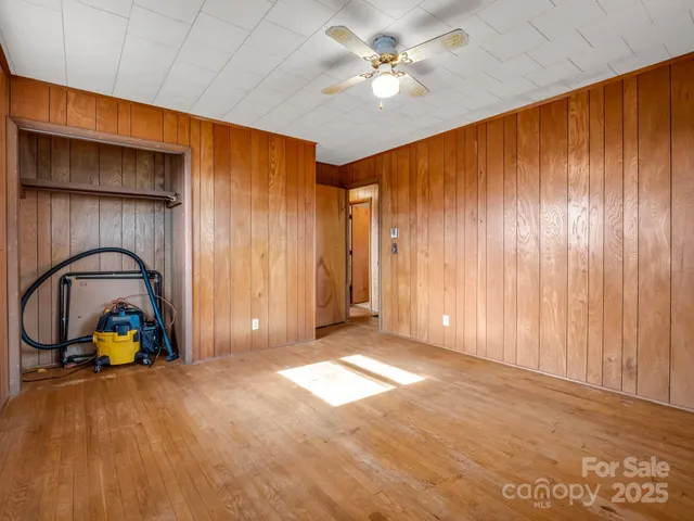 an empty room with windows and fan