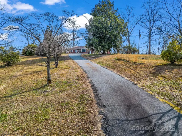 a view of a house with a yard and a tree