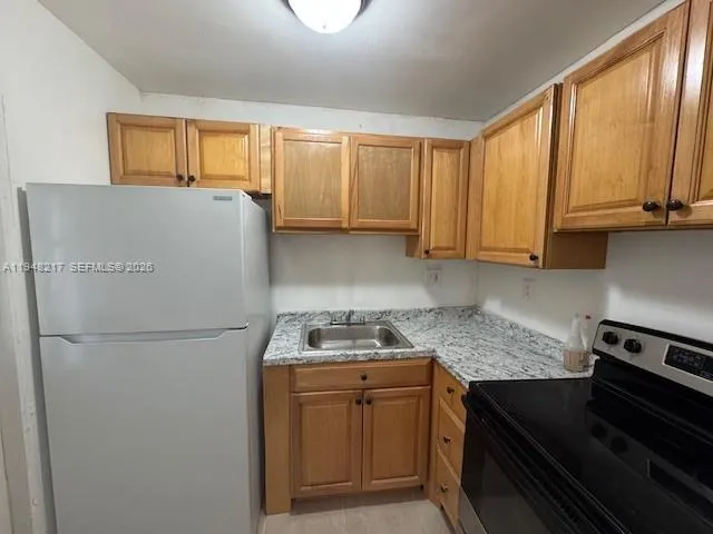 a kitchen with a refrigerator and a sink