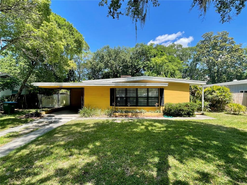 a front view of house with yard and trees in the background