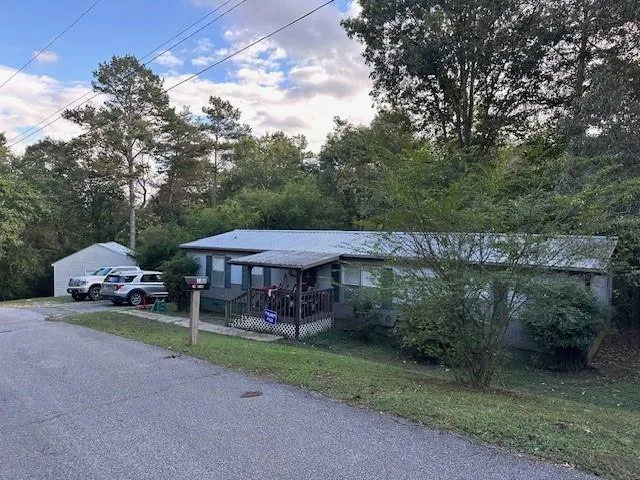 a view of a house with a yard and sitting area