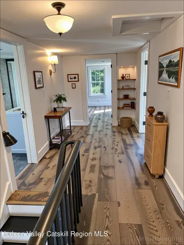 a view of a livingroom with furniture a window and wooden floor