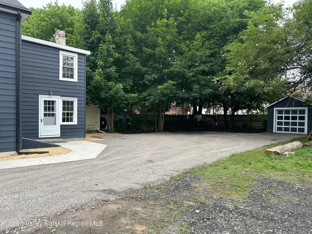 a view of a yard with a car parked in front of it