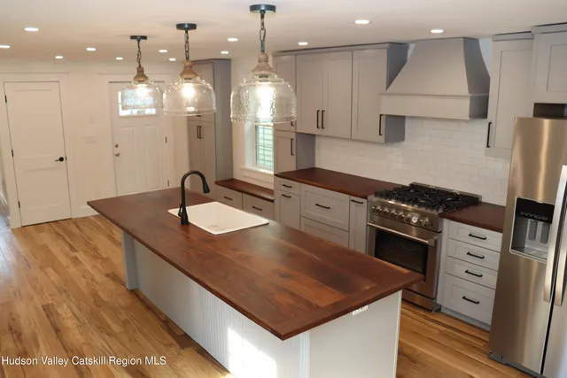 a kitchen with stainless steel appliances granite countertop a sink a stove and a refrigerator
