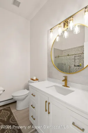 a bathroom with a sink a mirror and a toilet