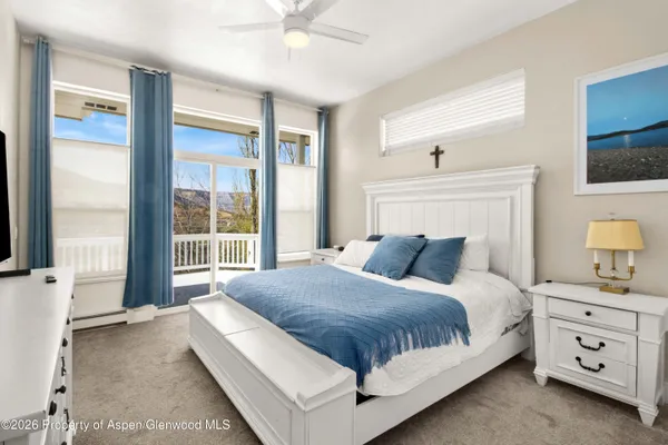 a bedroom with a large bed and a flat tv screen on a dresser