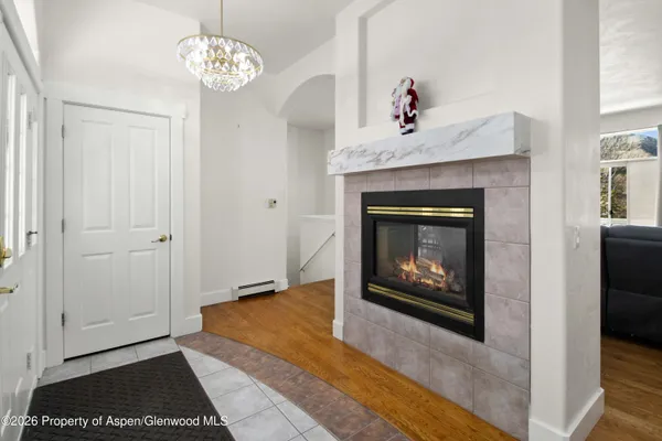 a living room with a fireplace and a chandelier