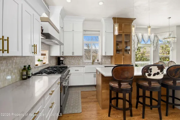 a kitchen with stainless steel appliances a table chairs and a stove