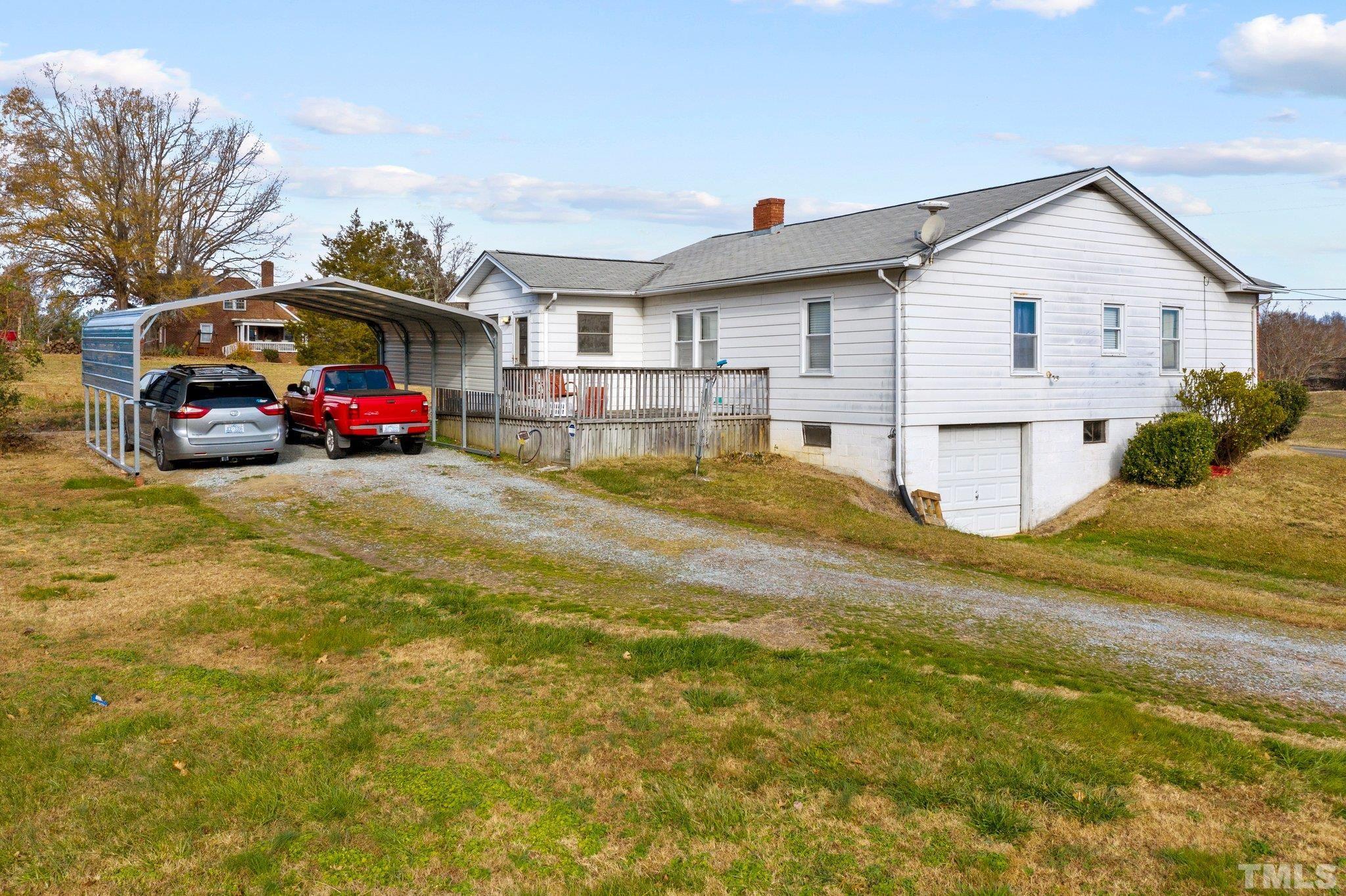 4966 Oxford Road Roxboro, NC 27574 - Photo 6 of 6 a view of a house with a yard and car parked
