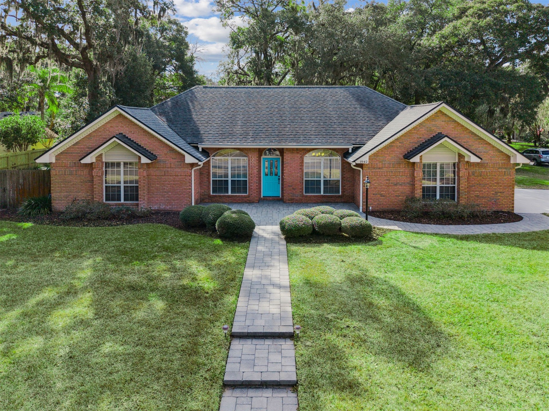 a front view of a house with a yard and trees