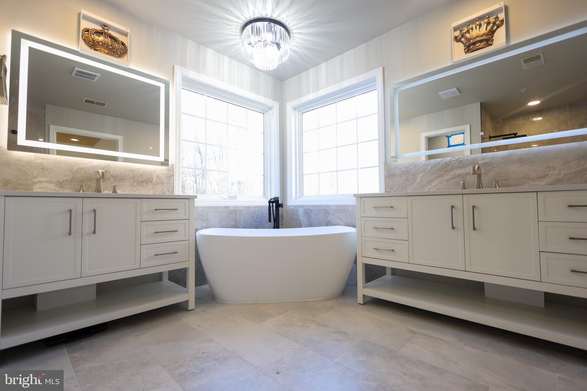 a bathroom with a bathtub a sink and a large mirror
