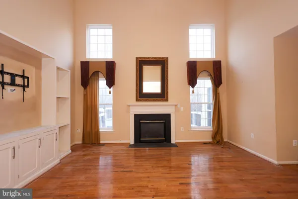 an empty room with windows and fireplace
