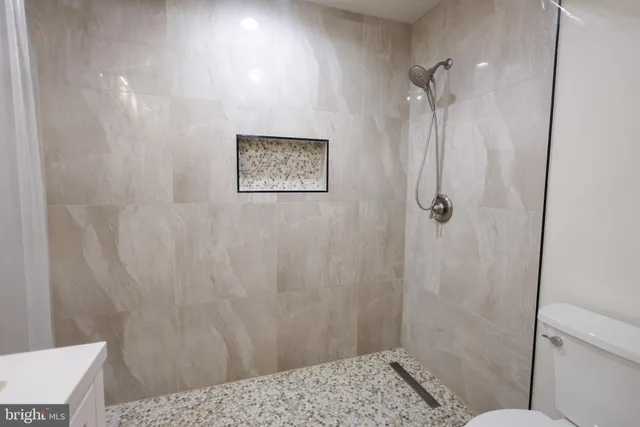 a bathroom with a double vanity sink toilet and a mirror