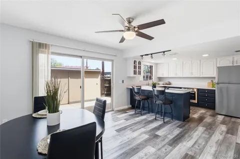 a living room with couches and kitchen view with wooden floor