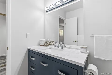 a bathroom with a sink vanity granite and a mirror