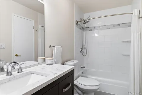 a bathroom with a granite countertop sink toilet and shower