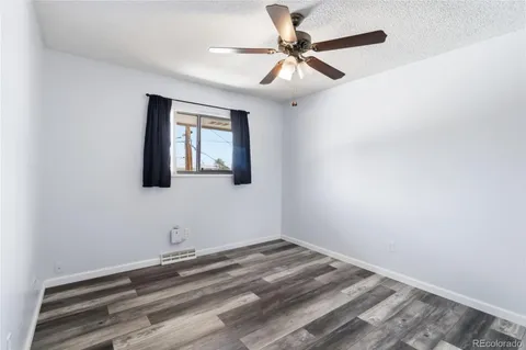 an empty room with a window and a ceiling fan