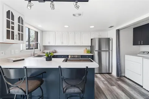 a kitchen with a dining table chairs refrigerator and cabinets