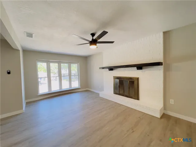 wooden floor in an empty room with a fireplace