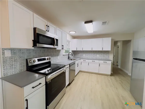 a kitchen with a sink a stove and microwave