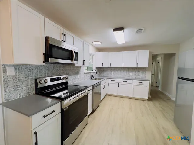 a kitchen with a sink a stove and microwave