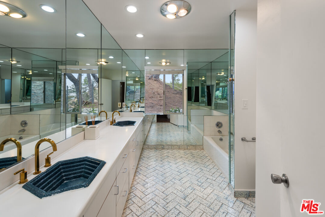 2526 Briarcrest Road Beverly Hills, CA 90210 - Photo 11 of 15 a bathroom with a granite countertop sink a toilet a mirror and shower