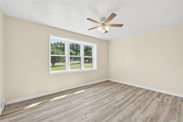a view of a room with wooden floor and windows