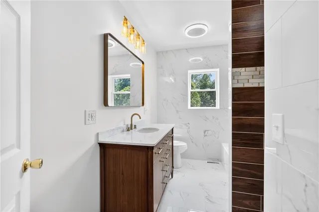 a bathroom with a sink a toilet and shower