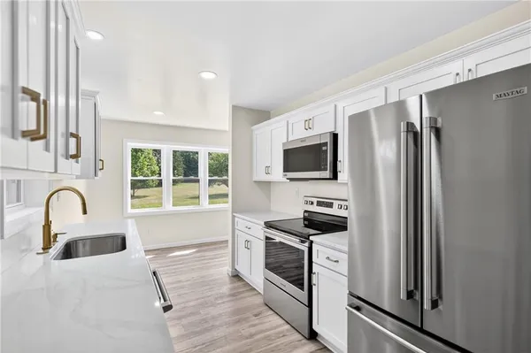 a kitchen with stainless steel appliances granite countertop a stove a sink and a refrigerator
