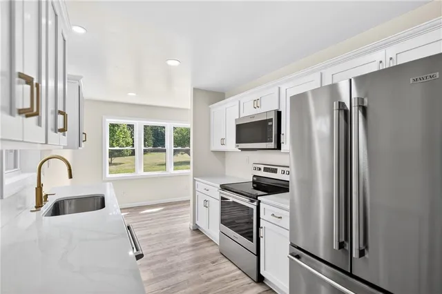 a kitchen with stainless steel appliances granite countertop a stove a sink and a refrigerator