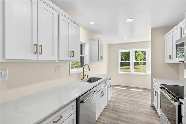 a kitchen with stainless steel appliances a sink stove and cabinets