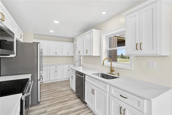 a kitchen with cabinets a sink and appliances