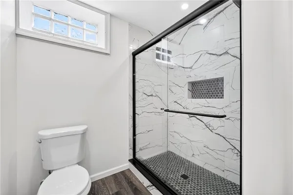 a bathroom with a toilet and a shower