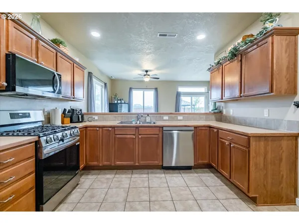a kitchen with stainless steel appliances granite countertop a stove a sink and a microwave