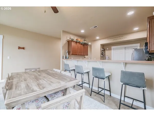 a kitchen with stainless steel appliances kitchen island granite countertop a stove a refrigerator a sink with a dining table and chairs