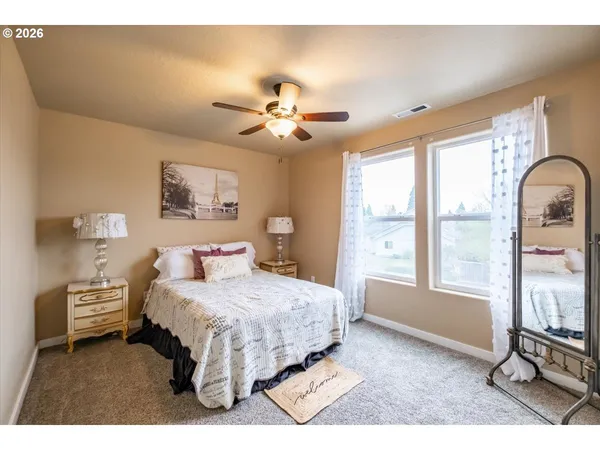 a bedroom with a bed chandelier and a large window