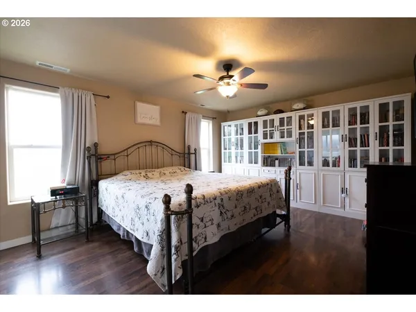 a bedroom with a bed ceiling fan and a window